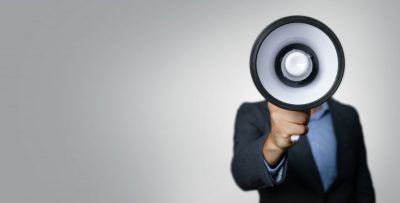 Businessman with a megaphone reporting news stories.