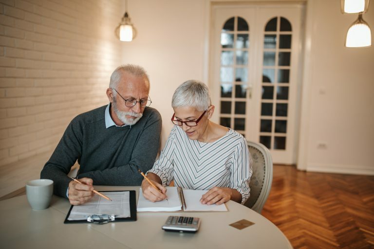 A senior couple taking a closer look at their budget in the comfort of their home, being inticed by risky investments